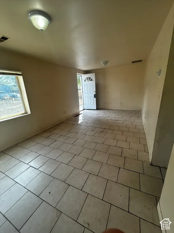 Tile flooring throughout, front entry door with glass insert, and a large window