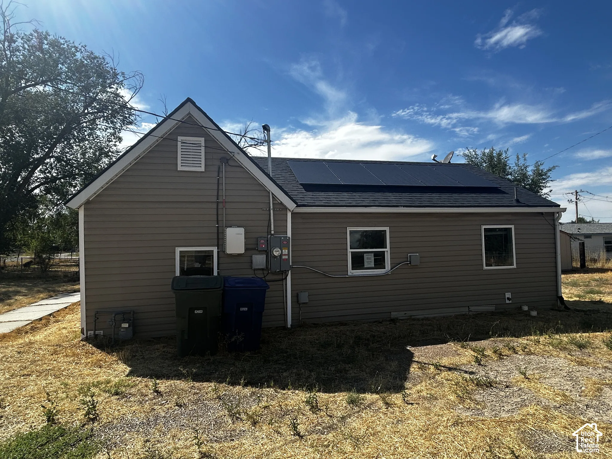 Side exterior with horizontal siding, a gable roof, and integrated solar panels