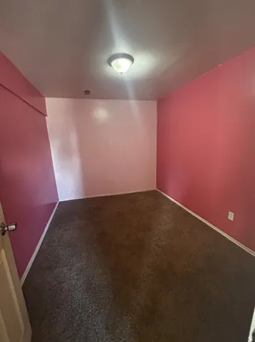 Textured carpet flooring, flush mount ceiling light fixture, and walls with varied paint finishes
