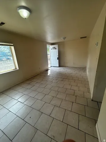 Tile flooring throughout, front entry door with glass insert, and a large window