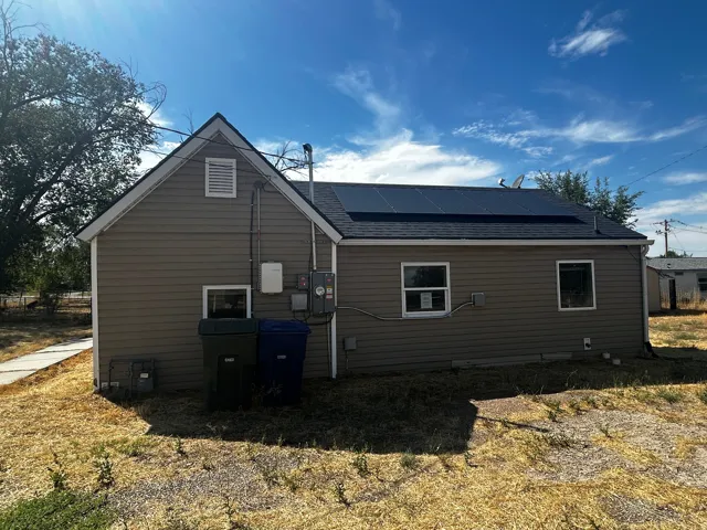 Side exterior with horizontal siding, a gable roof, and integrated solar panels