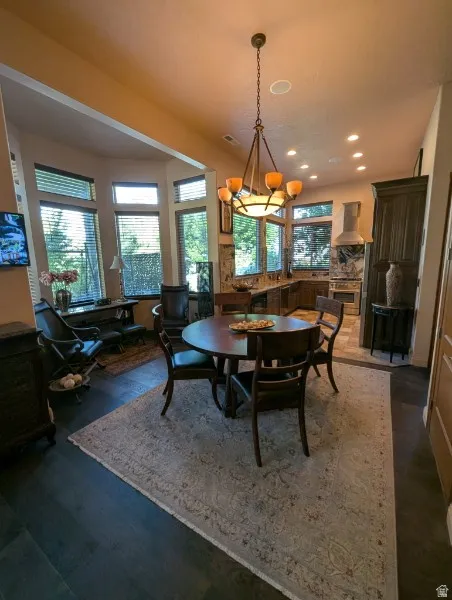 Open-concept living space featuring wood-finish flooring, recessed lighting, a chandelier, and a bay window with multiple panes