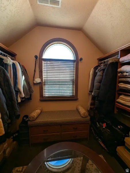 Primary bedroon colset with built-in wood shelving and drawers provide organization