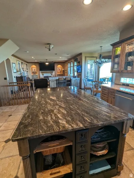 Large kitchen island with a patterned countertop, decorative cabinet details, and open shelving