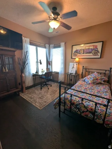 Dark wood-finish flooring with a ceiling fan light fixture