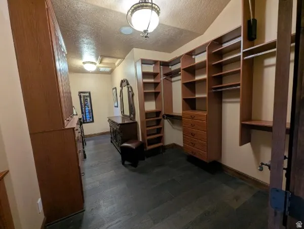 Primary bedroon colset with built-in wood shelving and drawers provide organization