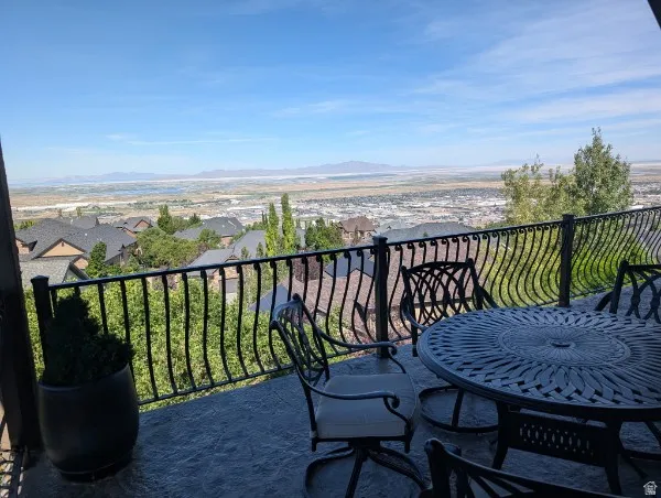 Stamped concrete patio with a decorative metal railing overlooking a distant cityscape and natural landscape