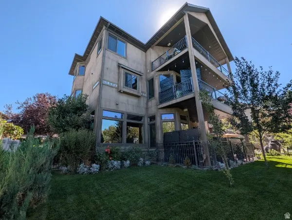 Multi-level exterior with two covered balconies featuring black wrought iron railings