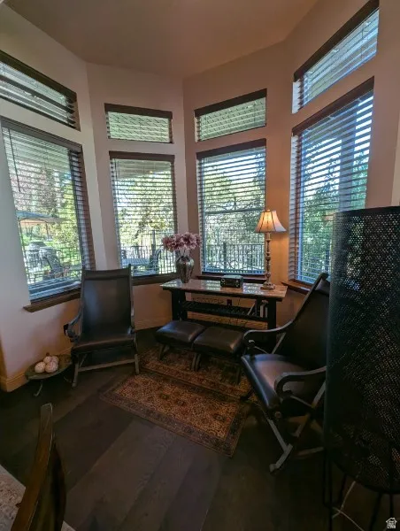 Bay window alcove with multiple windows, wood-finish flooring, and a decorative console table