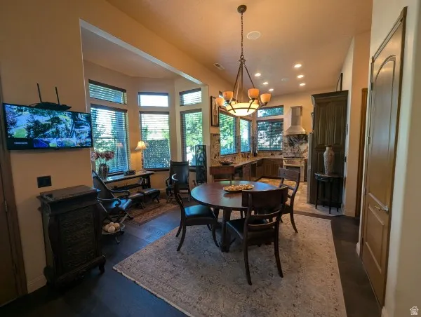 Spacious interior featuring dark wood-finish flooring, recessed lighting, a bay window with multiple panes, and a kitchen with dark cabinetry and stainless steel appliances