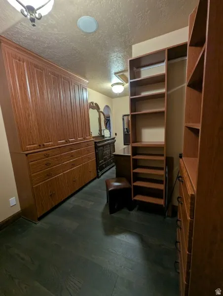 Primary bedroon colset with built-in wood shelving and drawers provide organization