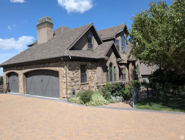 Stone and stucco exterior with multiple gables and arched window openings