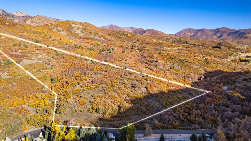 Expansive undeveloped land featuring natural terrain and distant mountain ranges