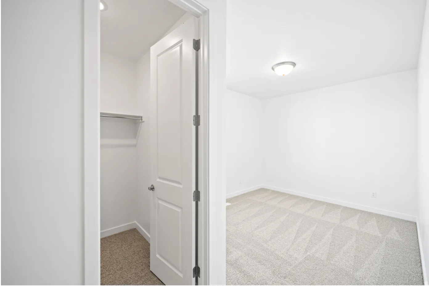 Room with neutral carpeting and a semi-flush mount ceiling fixture
