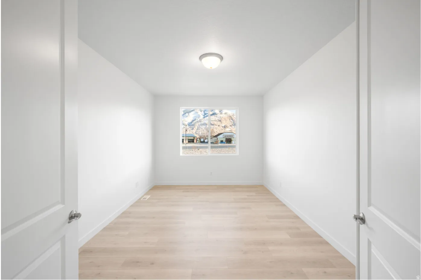 Light wood-finish flooring with white walls and trim
