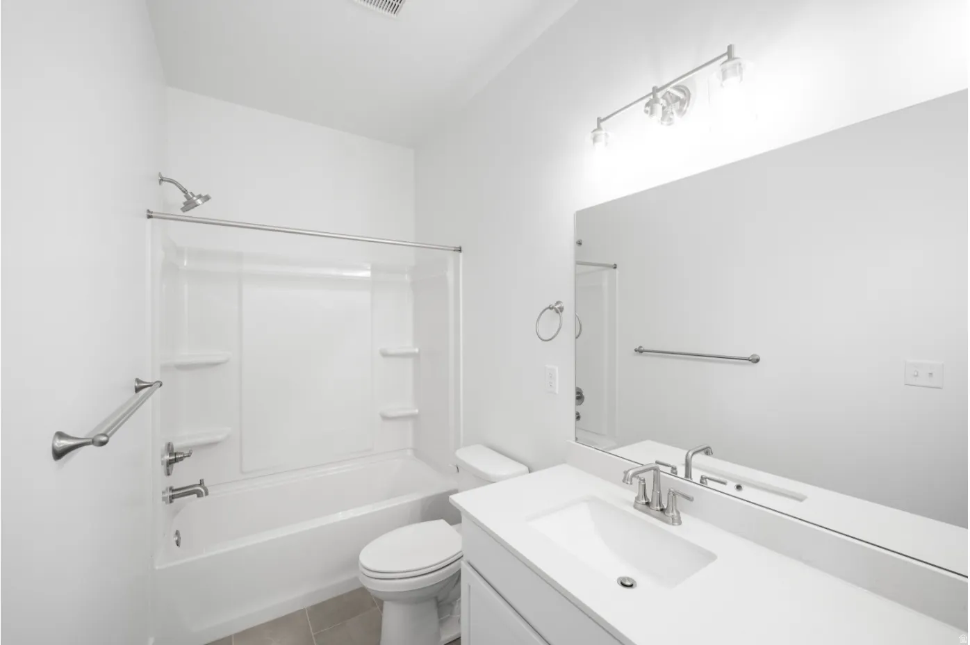 White vanity with integrated sink, brushed nickel faucet, large mirror, and overhead vanity lighting