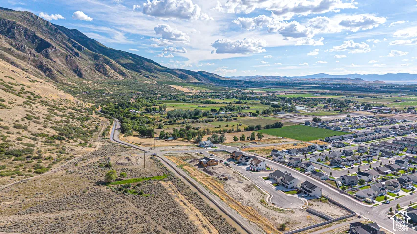 Expansive mountain backdrop with a visible road and surrounding development