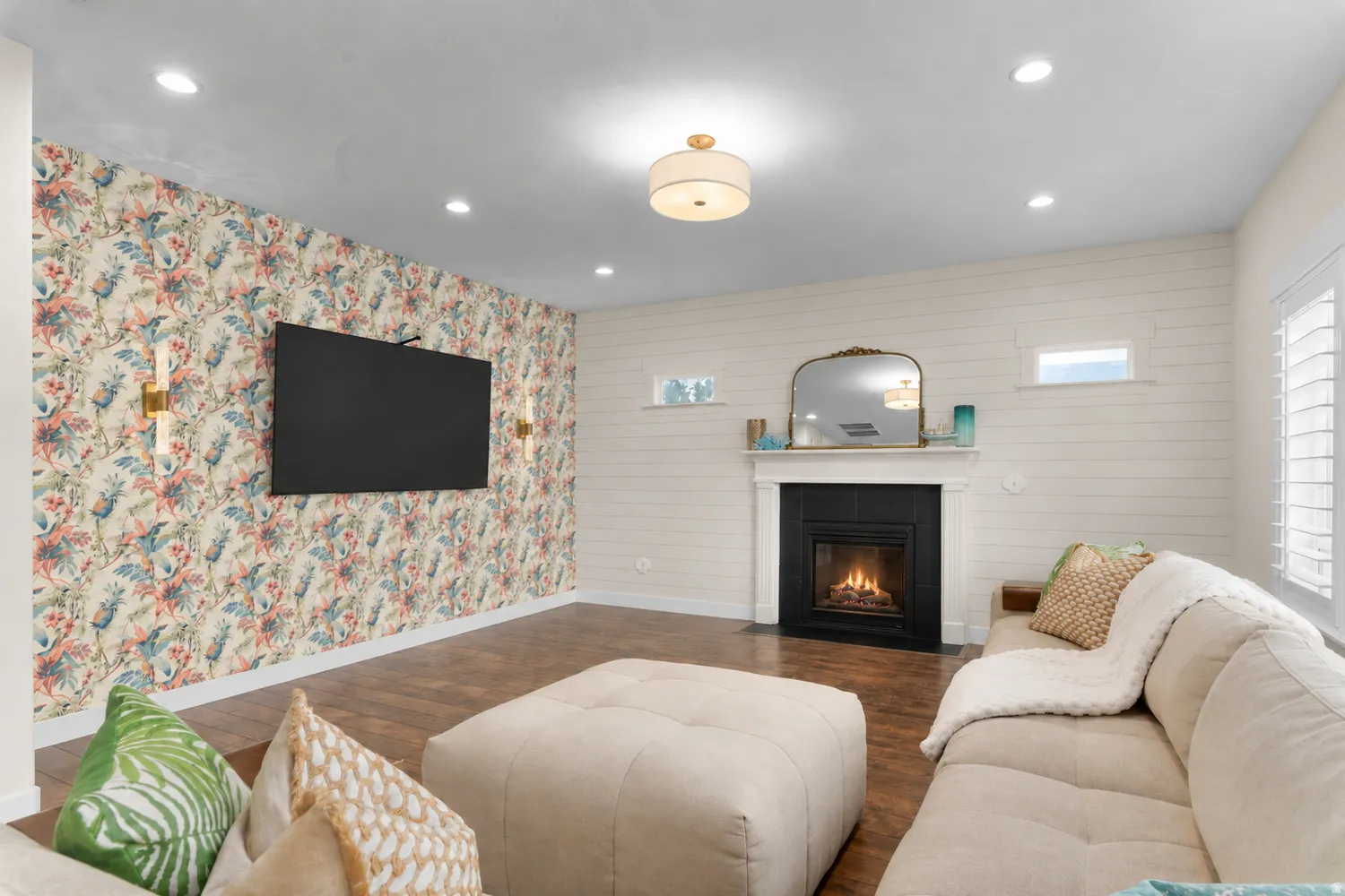Wood-finish flooring, accent wall with botanical wallpaper, recessed lighting, white shiplap wall, and a built-in fireplace