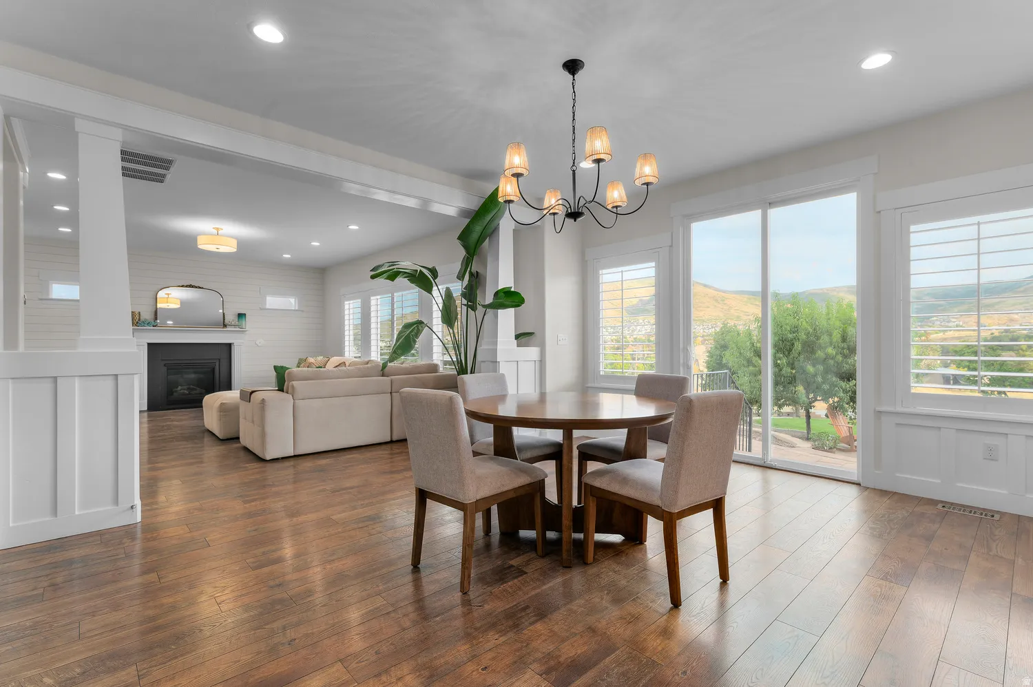 Hardwood-finish flooring, recessed lighting, and a modern chandelier illuminate this open space