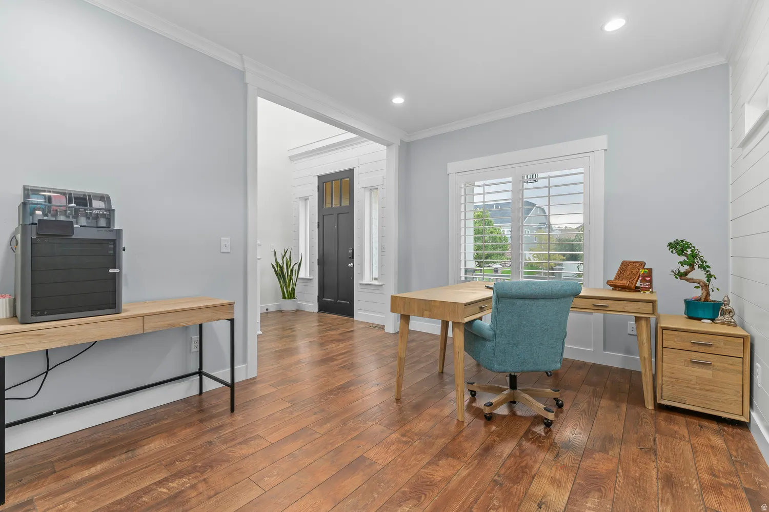 Wood-finish flooring throughout, recessed lighting, and a window with plantation shutters