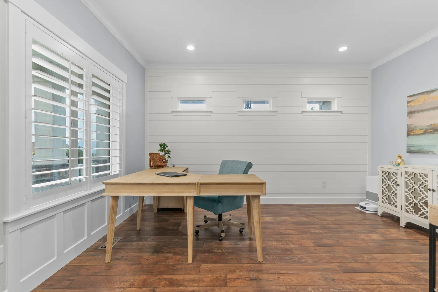 Wood-finish flooring complemented by a white paneled accent wall