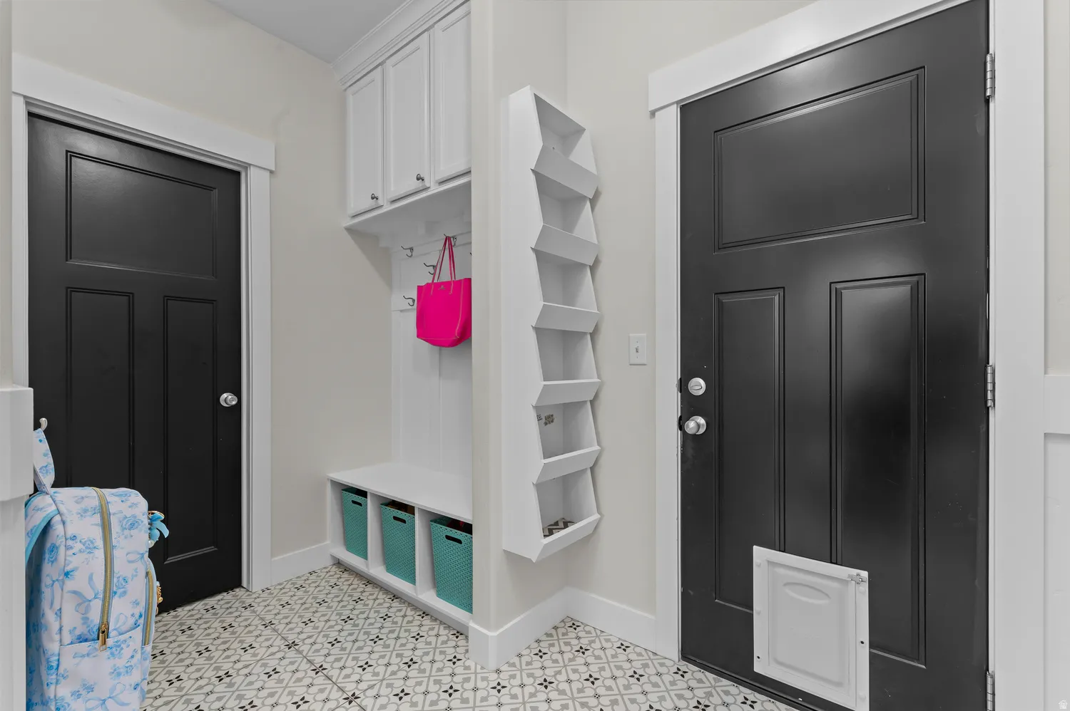 Built-in storage solutions, patterned tile flooring, and contrasting black paneled doors