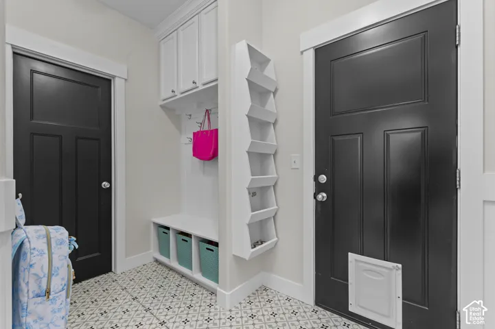 Built-in storage solutions, patterned tile flooring, and contrasting black paneled doors