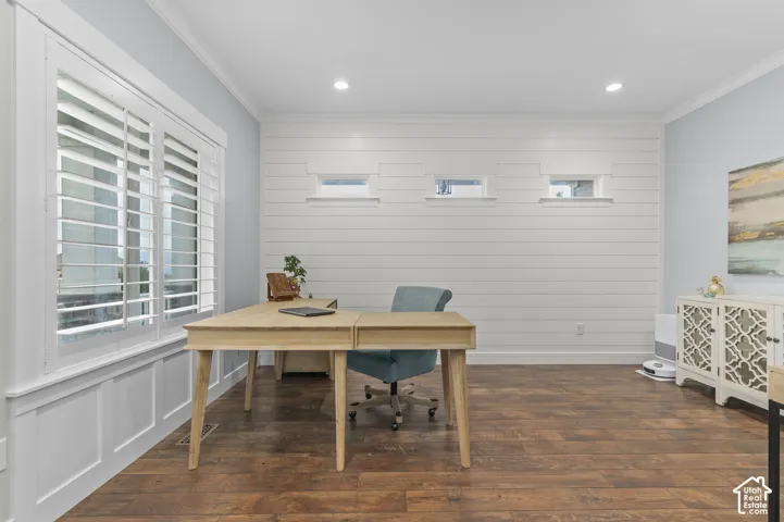 Wood-finish flooring, white plantation shutters, decorative wall paneling, recessed lighting, and crown molding