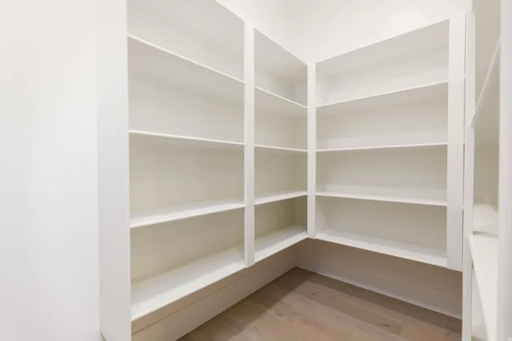 Built-in shelving with multiple storage levels and wood-finish flooring