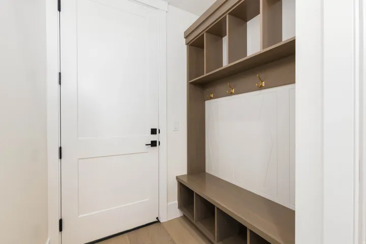 Built-in mudroom bench with storage cubbies, integrated shelving, and wall hooks