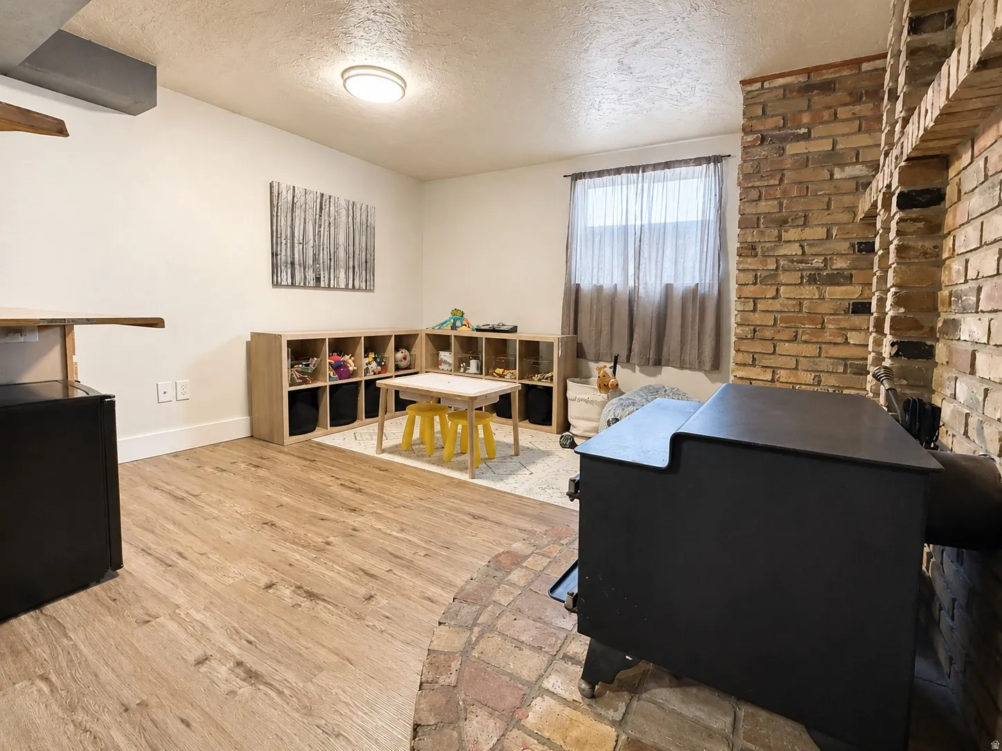 Huge basement family room with original brick, wood-burning stove, and dry bar. This area could be converted into a 4th bedroom.