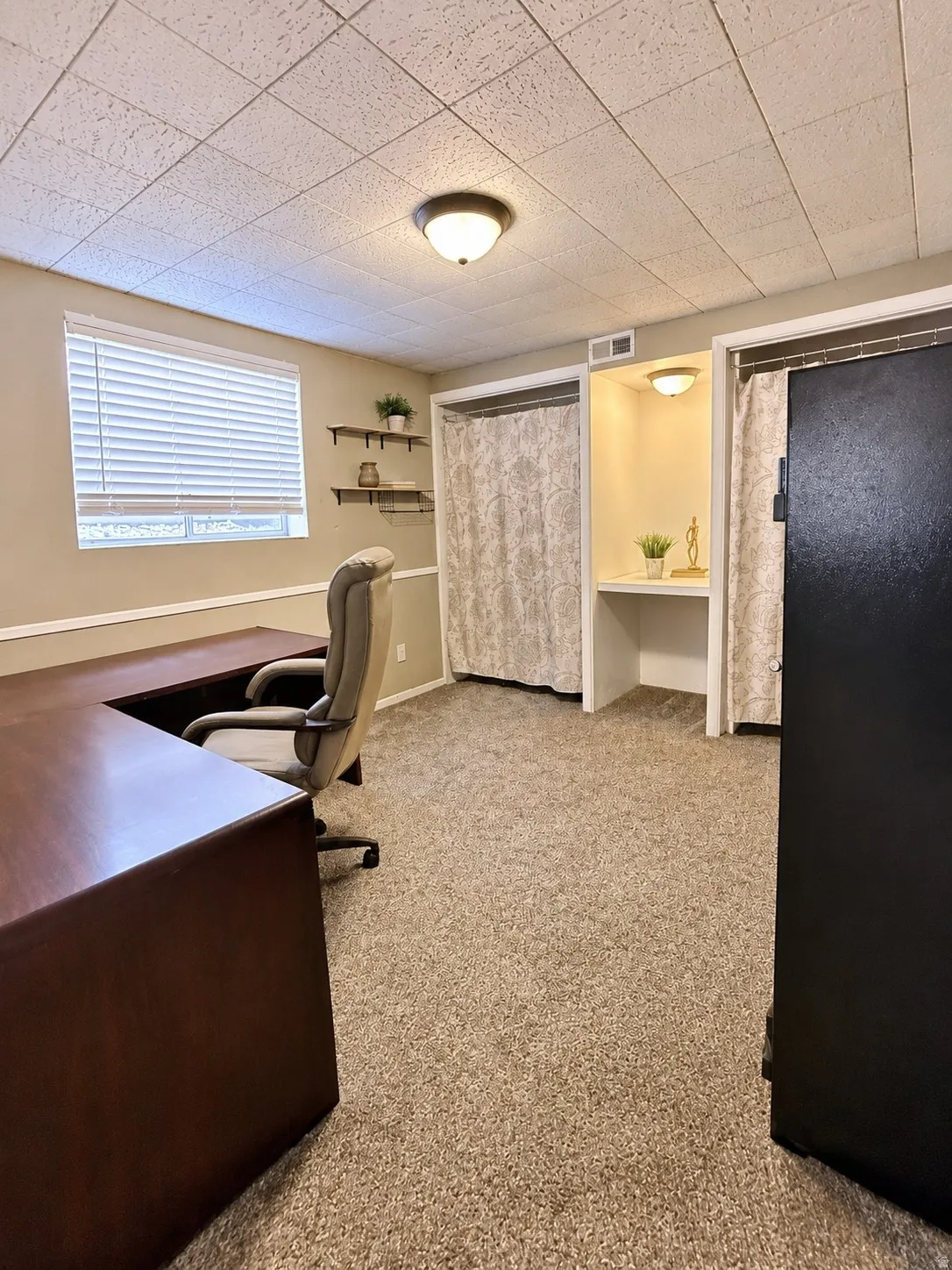 Basement bedroom/office with 2 closets and built-in desk.