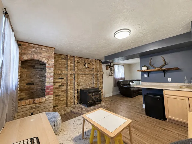Huge basement family room with original brick, wood-burning stove, and dry bar. This area could be converted into a 4th bedroom.