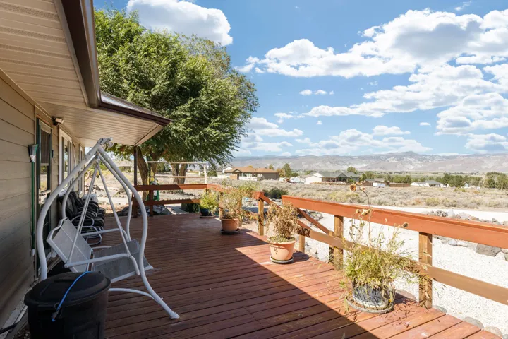 Expansive wood deck with a stained wood railing and mountain scenery