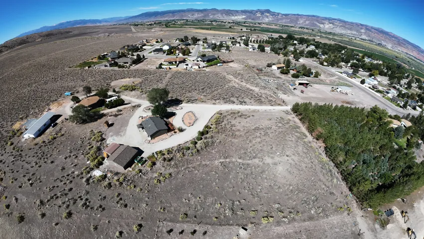 Expansive undeveloped land featuring natural terrain and distant mountainous backdrop