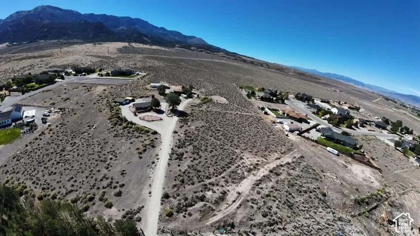 Expansive desert landscape featuring scattered residences and mountain backdrops