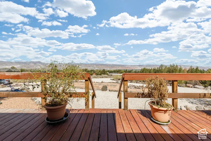Wood-finish deck with a rustic wooden railing and expansive natural landscape