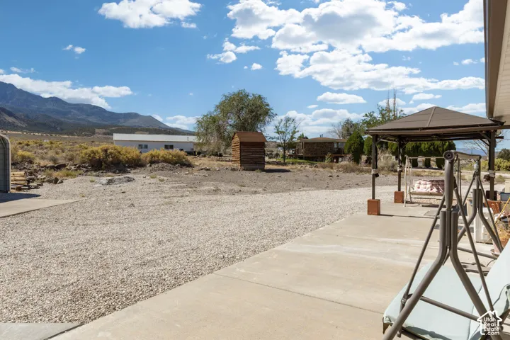 Gravel parking area, concrete patio, and a covered outdoor structure