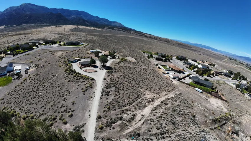 Expansive desert landscape featuring scattered residences and mountain backdrops