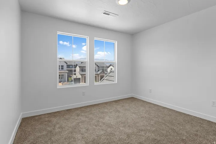 Neutral-toned carpeting with white baseboards