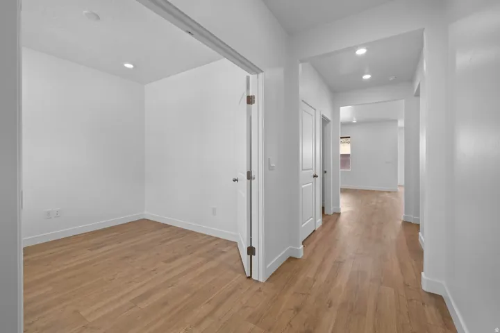 Recessed lighting throughout, wood-finish flooring, white trim, and solid core doors