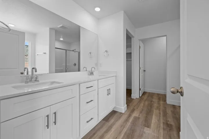 Dual vanity with undermount sinks, chrome fixtures, and white cabinetry