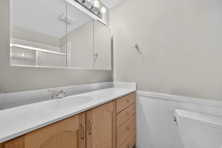 Wood-finish vanity with an integrated sink and light-toned countertop