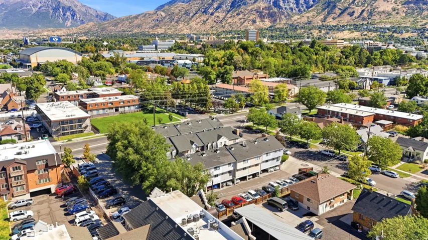 Multi-story residential buildings set against a backdrop of mountains and a city skyline