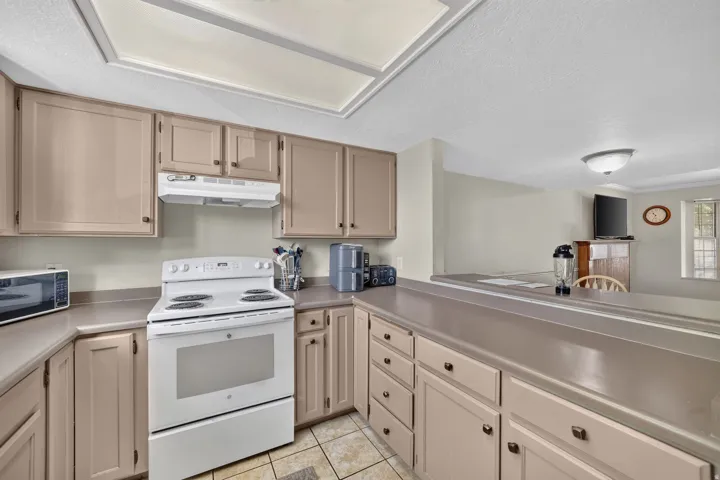 Kitchen featuring extensive cabinetry, white electric range, and a breakfast bar