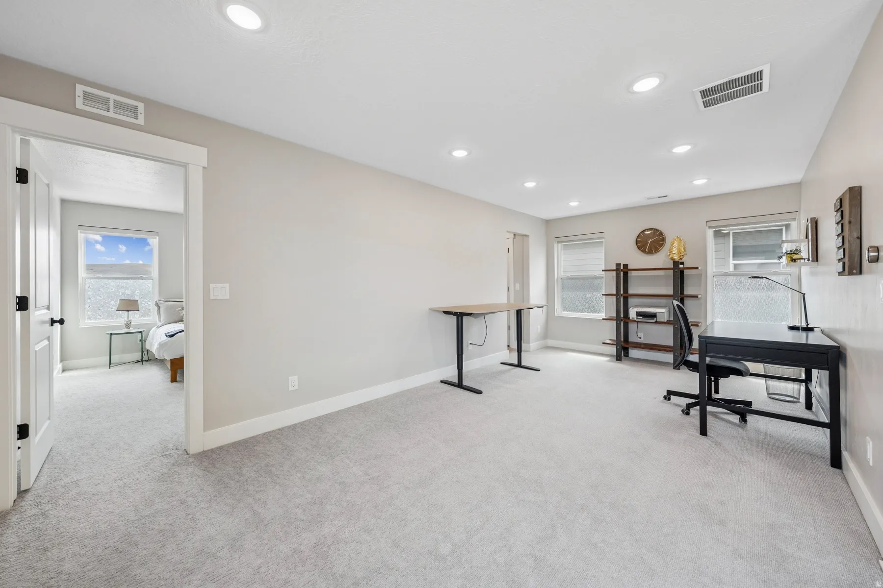 Recessed ceiling lighting, light gray wall paint, and light gray carpeting