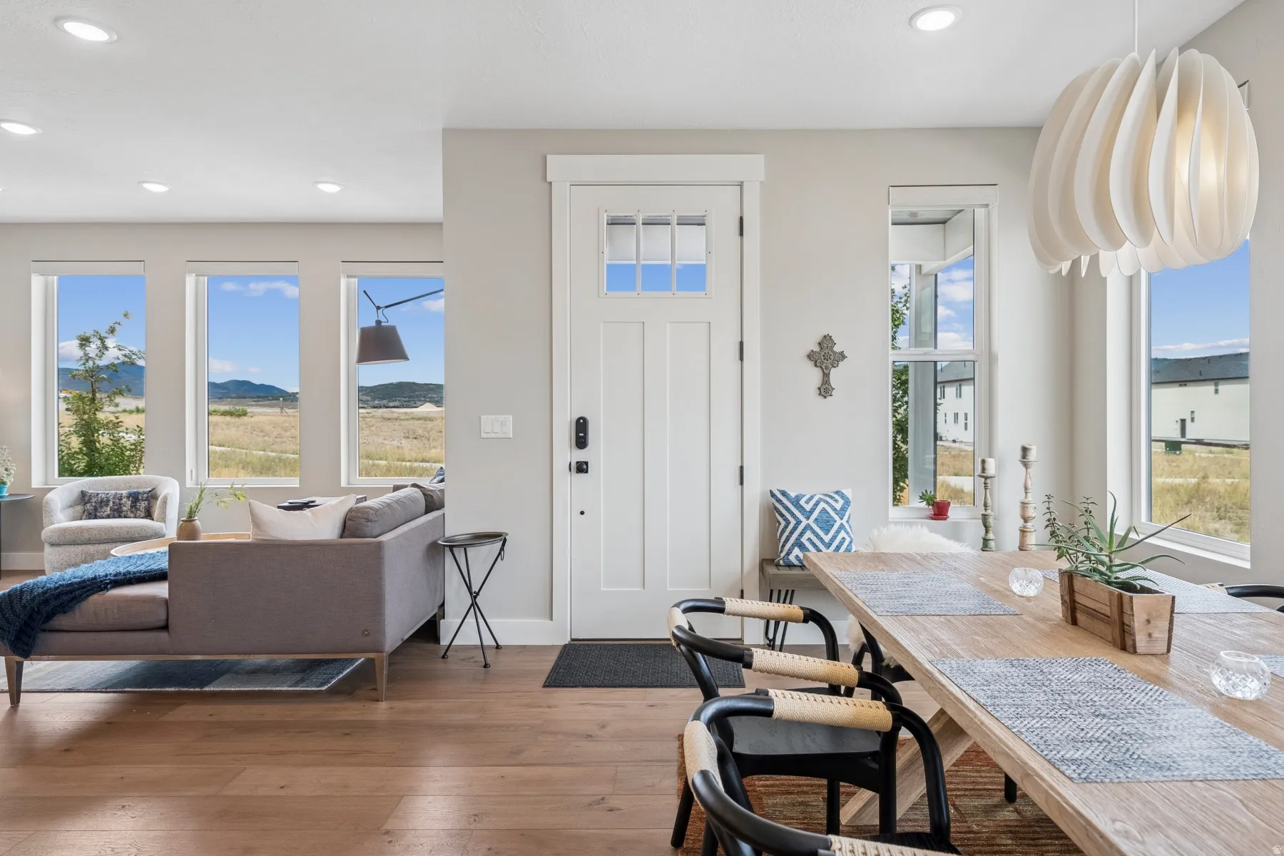 Open-concept living space with wood-finish flooring, recessed lighting, and expansive windows