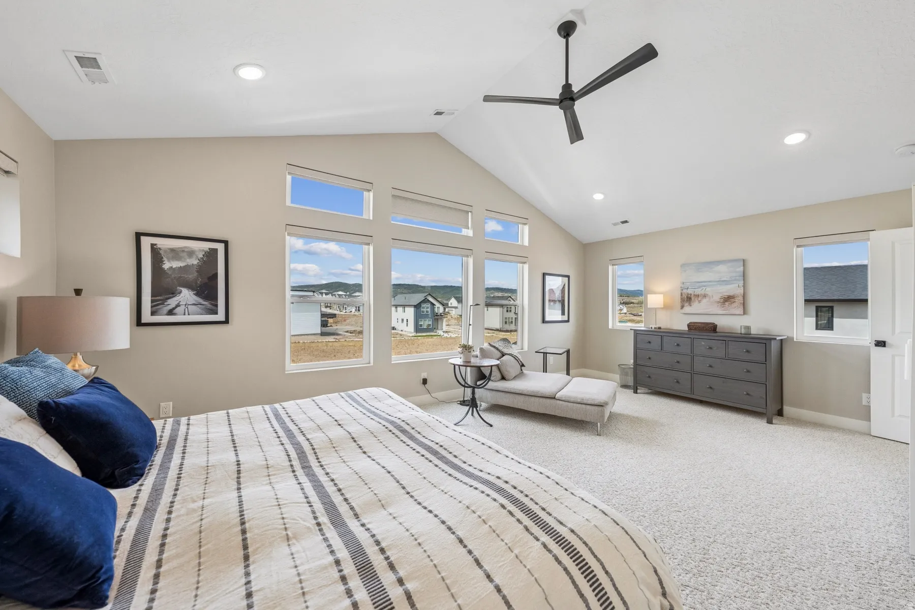 Vaulted ceiling with a contemporary ceiling fan, recessed lighting, and multiple windows