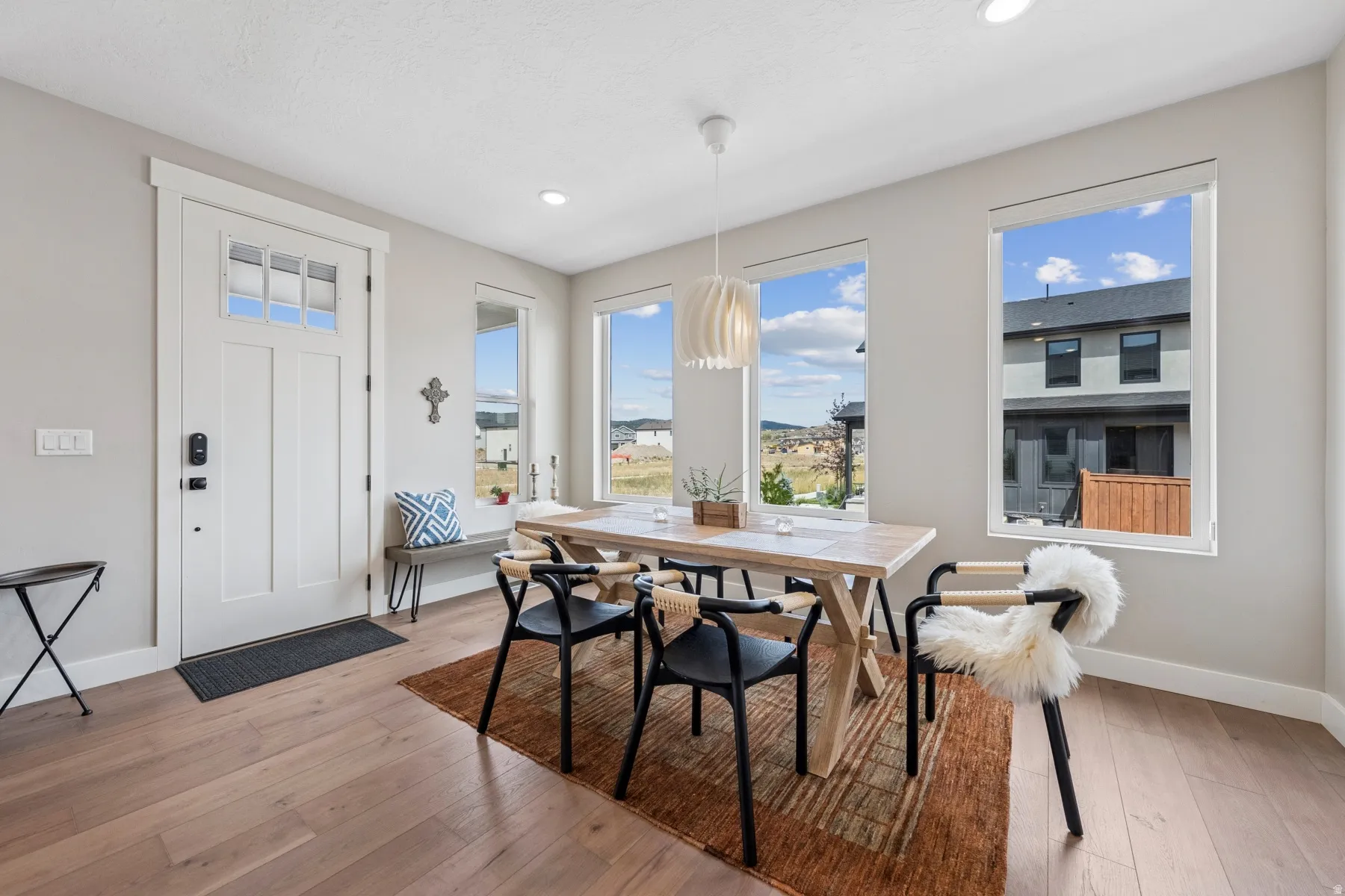 Hardwood-style flooring throughout, an entry door with upper window panes, recessed lighting, and multiple windows providing natural illumination