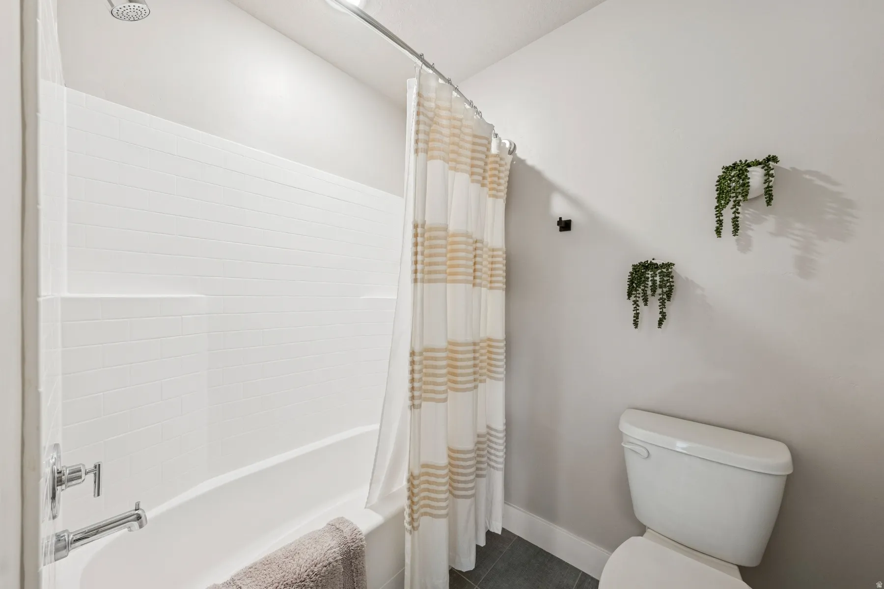 Tub and shower combination featuring a white subway tile surround and chrome fixtures